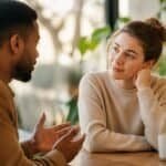 Two people listening to each other in a calm conversation, representing understanding and empathy for others.